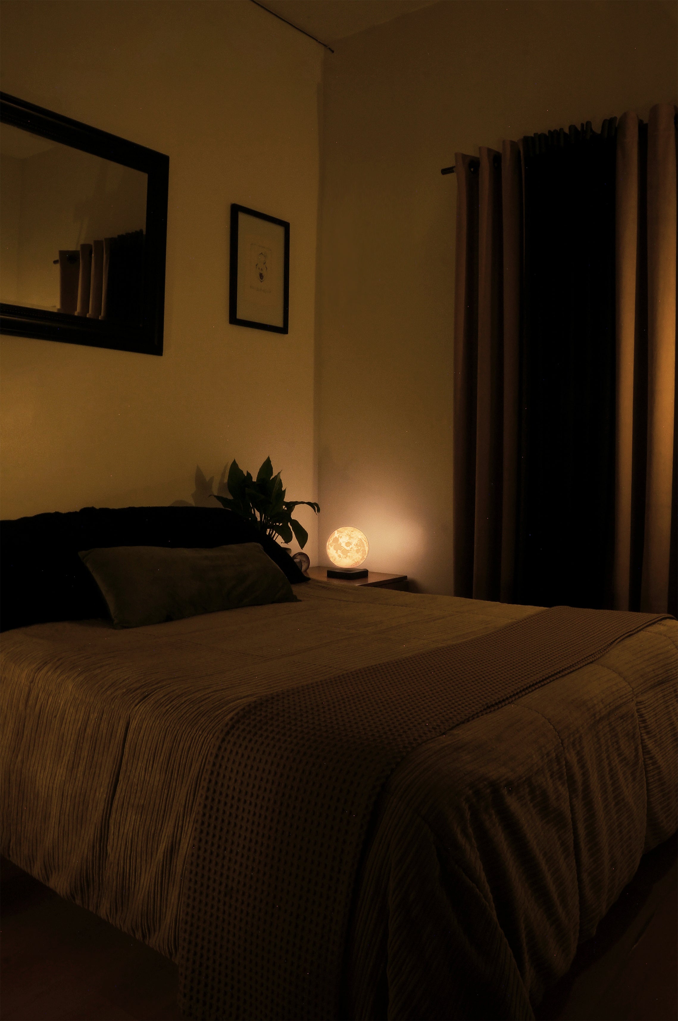 Iluminación cálida en recámara moderna con luz ambiental y lámpara de buró de luna flotante